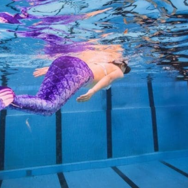 Mermaid Class-Child swimming with a colorful mermaid tail at Marina Swim School's mermaid-themed swim program
