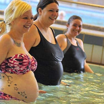 Pregnant woman participating in a prenatal swim class at Marina Swim School, guided by a certified instructor