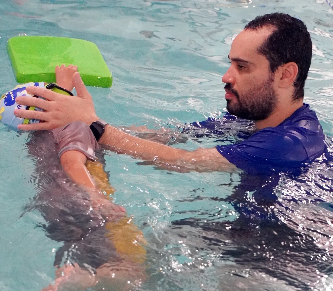 Marina’s Swim School instructor teaching a young swimmer how to perform a side glide position for efficient movement in the water.