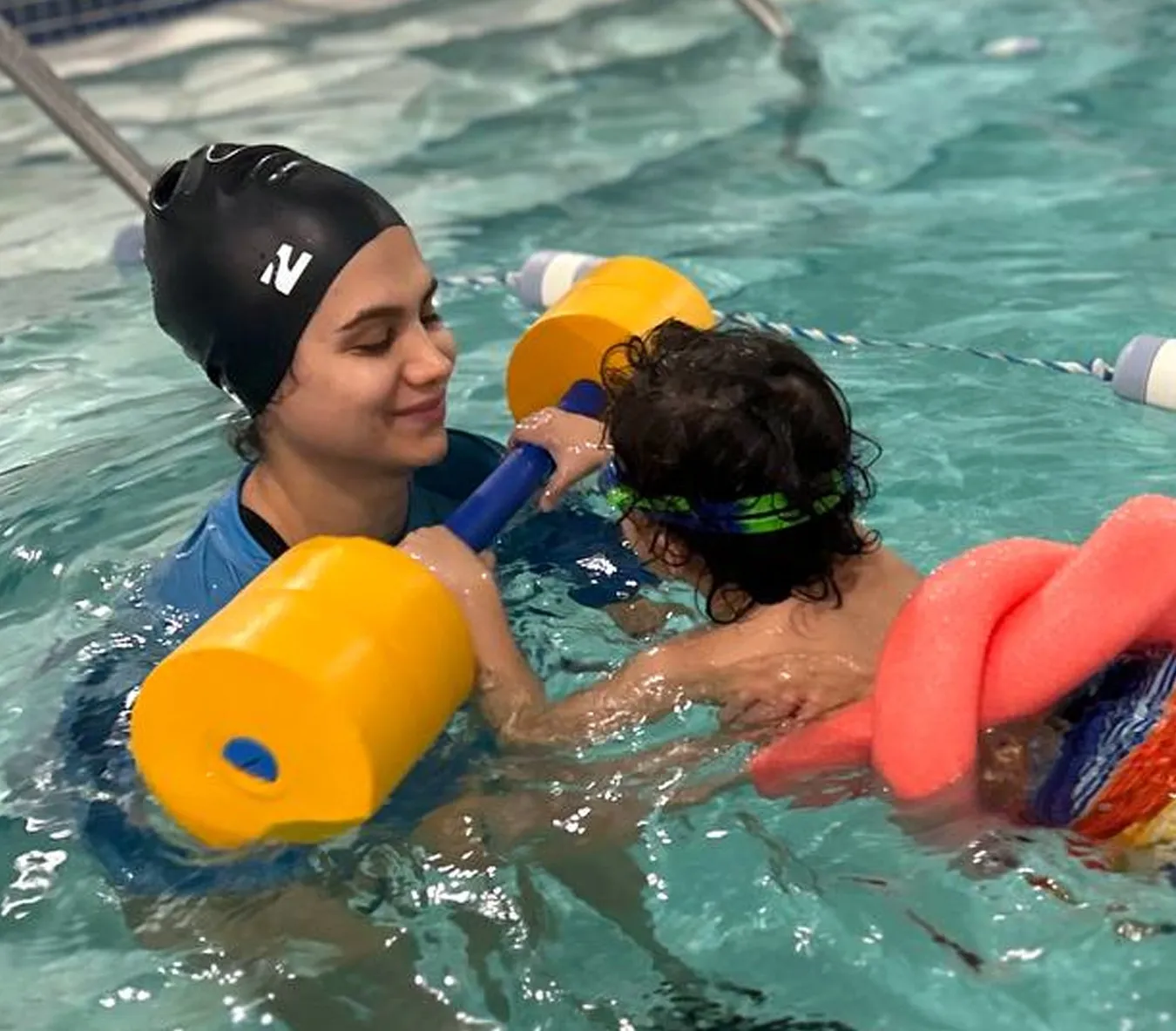 Marina’s Swim School instructor teaching a young swimmer how to blow bubbles in the water to build breath control and confidence.