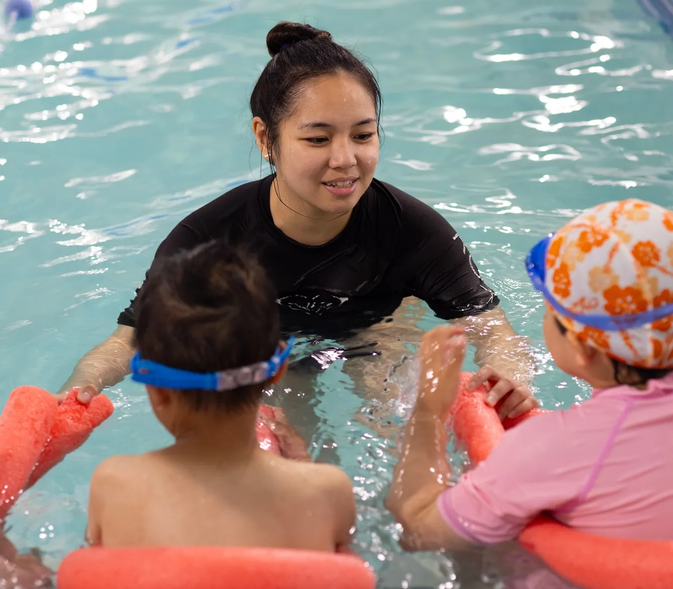 Marina’s Swim School instructor teaching a group of young swimmers in a warm indoor pool.