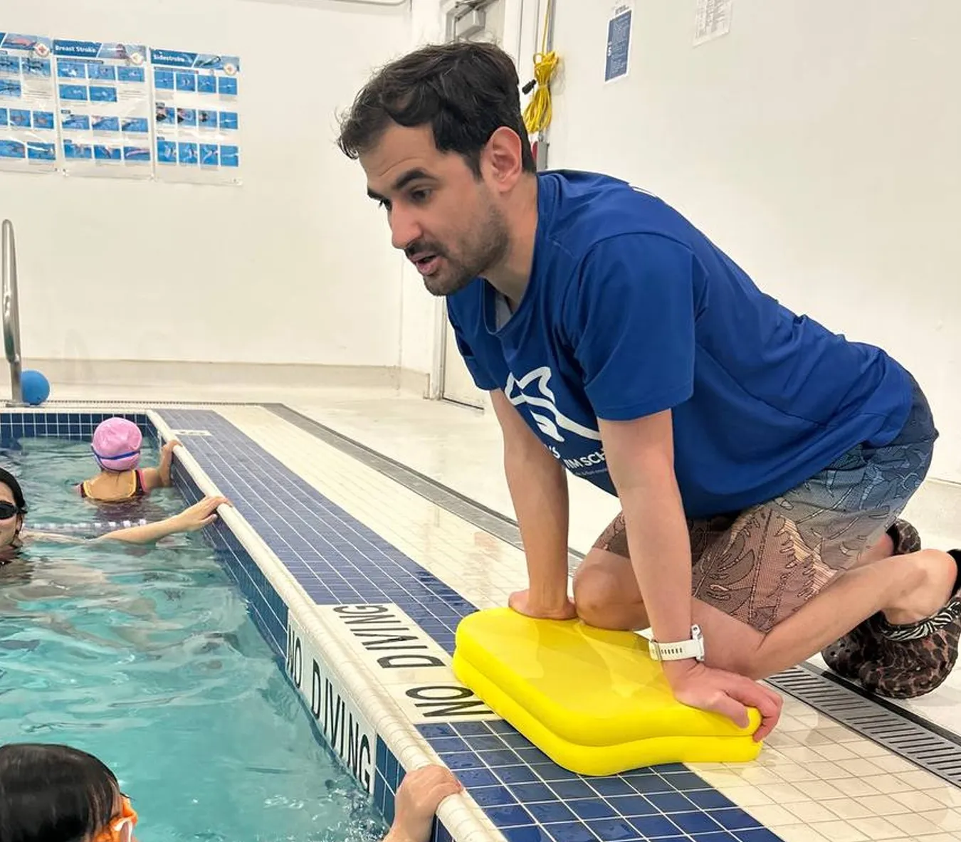 Marina’s Swim School instructor communicating with a young swimmer to give instructions and feedback during a lesson.