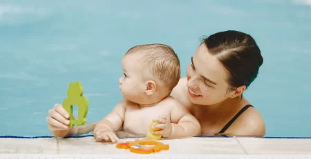 Mother and little son enjoying swimming in a swimming pool