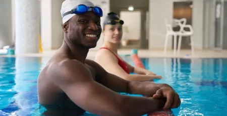 Adult swim class at Marina’s Swim School with students practicing in a warm indoor pool, available in Vancouver, Ontario, and Florida.